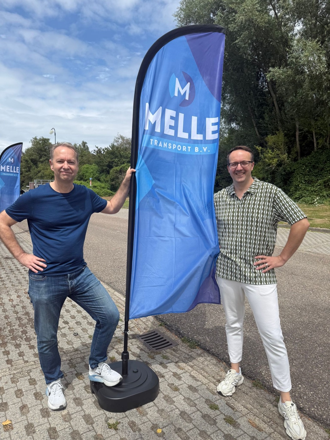 Teamleden bij de Melle Transport-vlag tijdens het 10-jarig jubileum