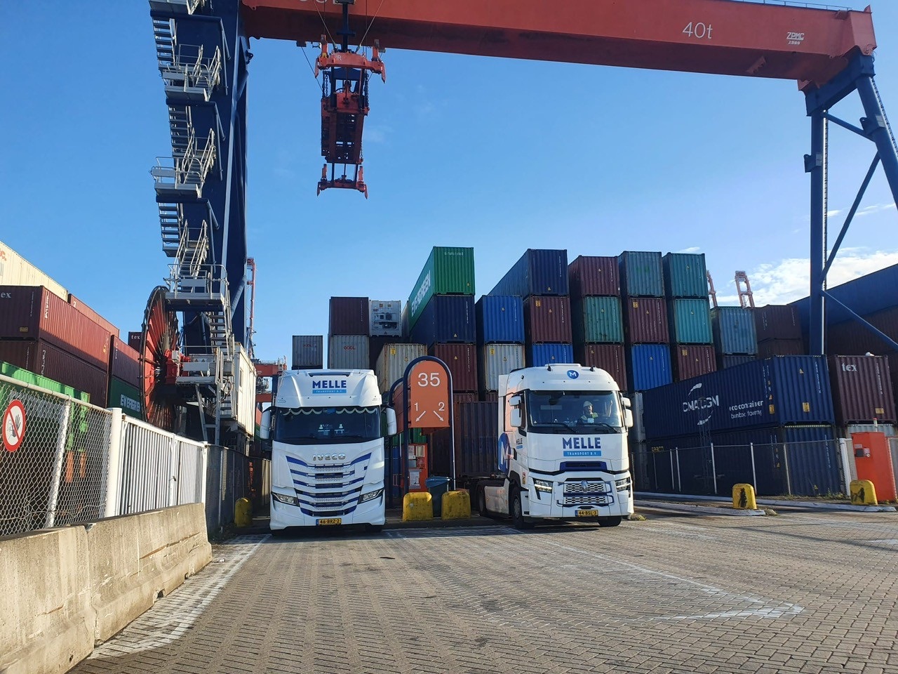 Twee trucks van Melle Transport onder de containerkraan bij de deep-sea terminal