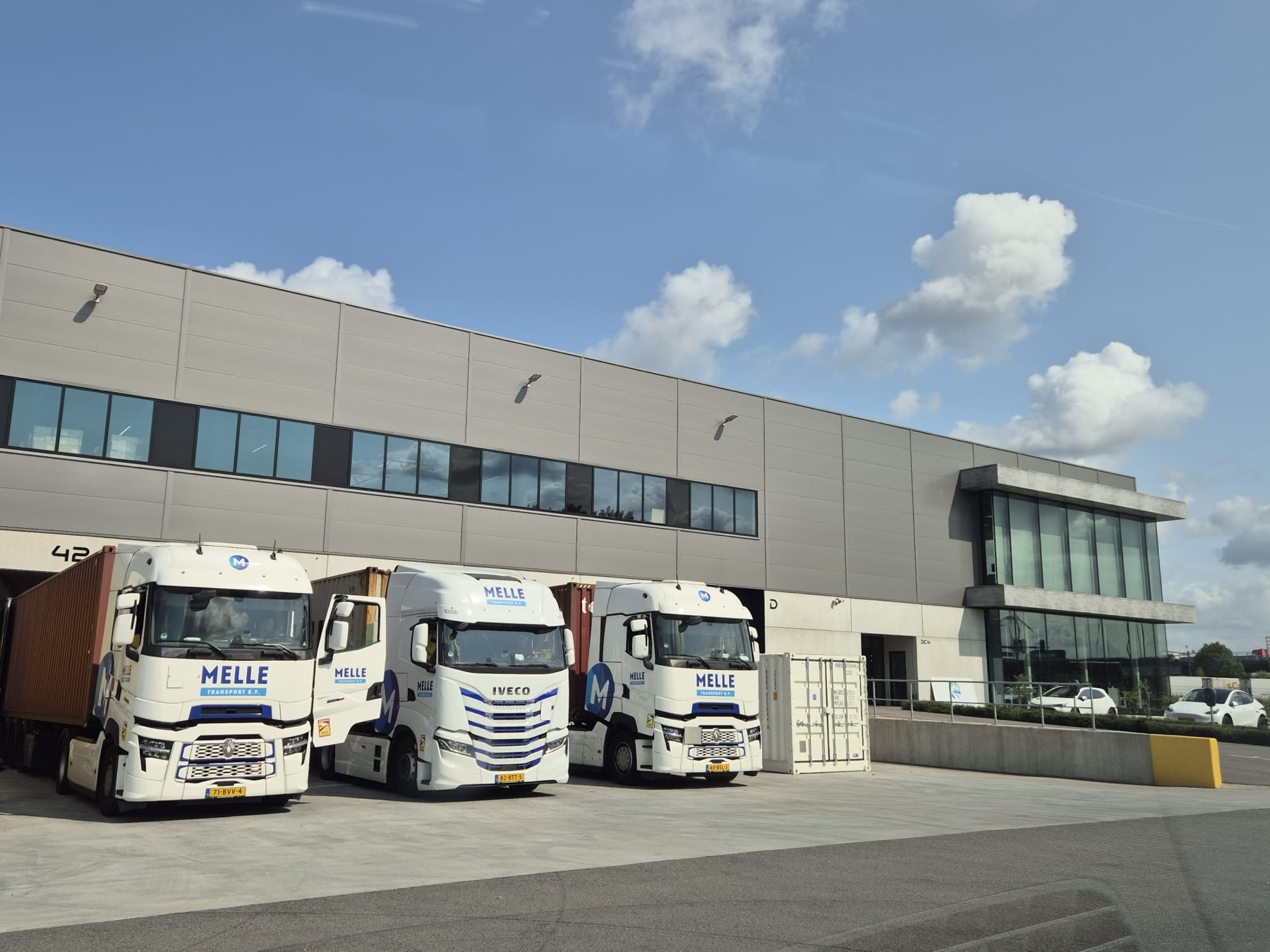 De loods van Melle Transport met meerdere laaddocks en trucks voor de deuren